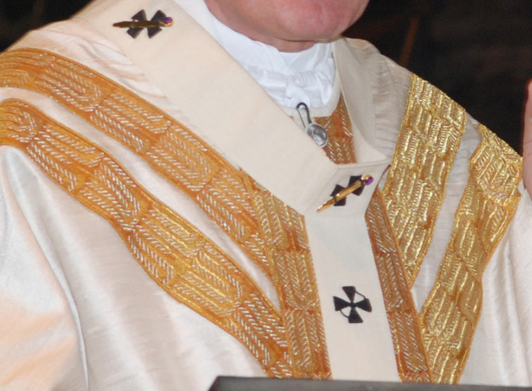 Pallium: mit schwarzen Kreuzen bestickt und mit drei Nadeln festgesteckt